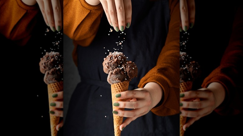 Person sprinkling salt on chocolate ice cream