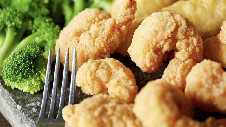 Fried shrimp on plate with broccoli and fork