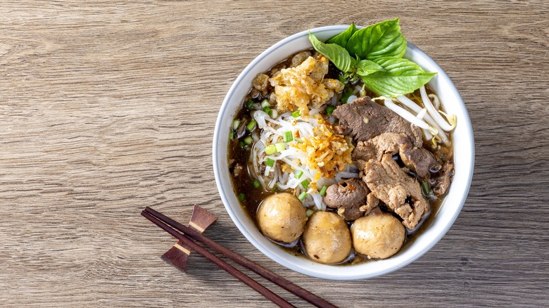 A bowl of Thai boat noodles on a table