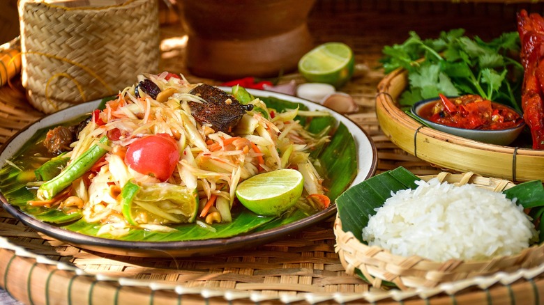 A som tam salad next to sticky rice