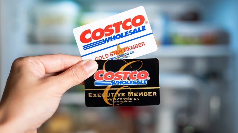 Costco membership cards held in front of fridge