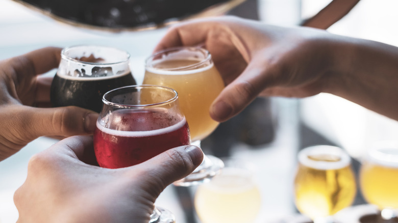 Friends toasting beer glasses at brewery