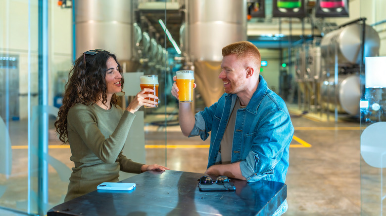 Happy couple enjoying beer at brewery