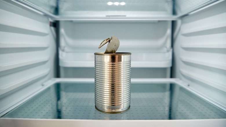 Open aluminum can in refrigerator with ring-tab top partially lifted up