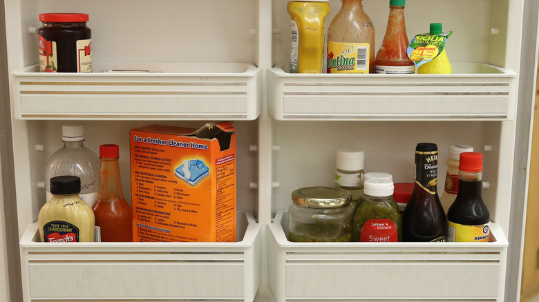 Open box of baking soda in a refrigerator door shelf