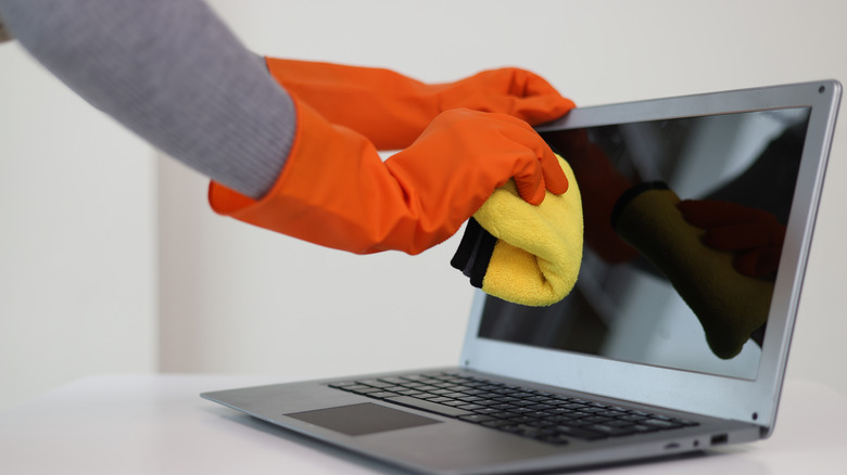 Person cleaning a screen with a towel