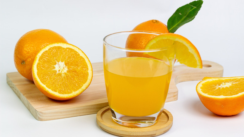 Glass of fresh-squeezed orange juice with sliced oranges