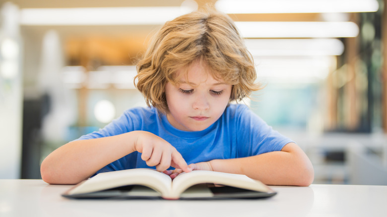 kid reading through cookbook