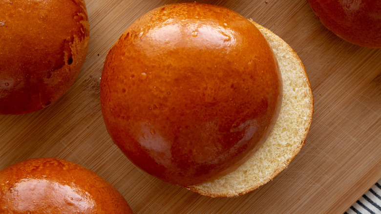 Brioche hamburger buns on wooden board