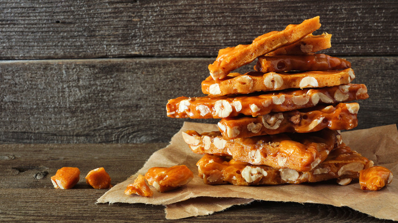 Pieces of peanut brittle on a brown paper