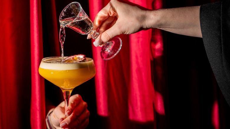 adding extra liquor from a small carafe