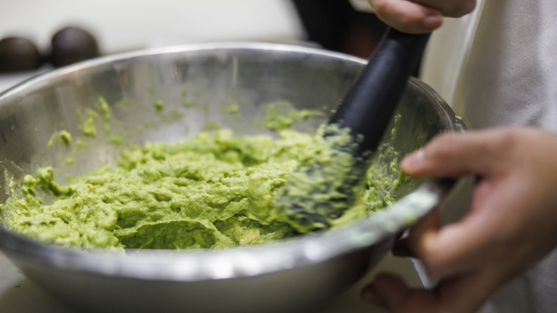 Guacamole is mixed in a bowl