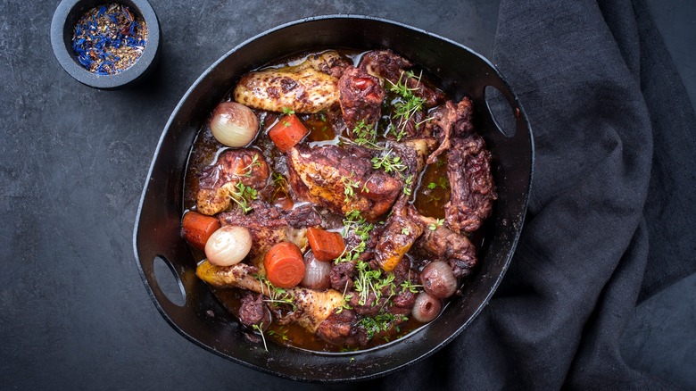 Coq au vin in a black serving dish