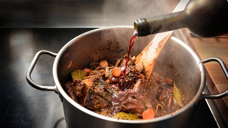 Beef bones, carrots, and onions in a roasting pan