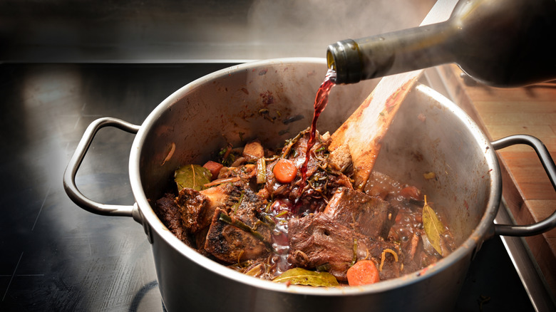 A person pouring wine into stock