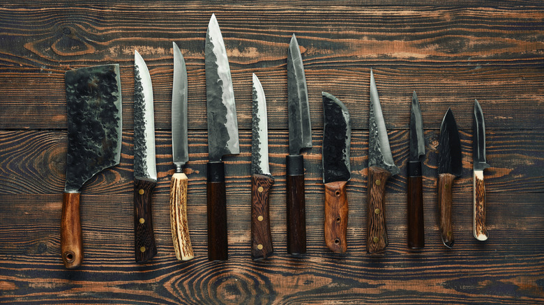 A variety of chef's knives on a wooden table