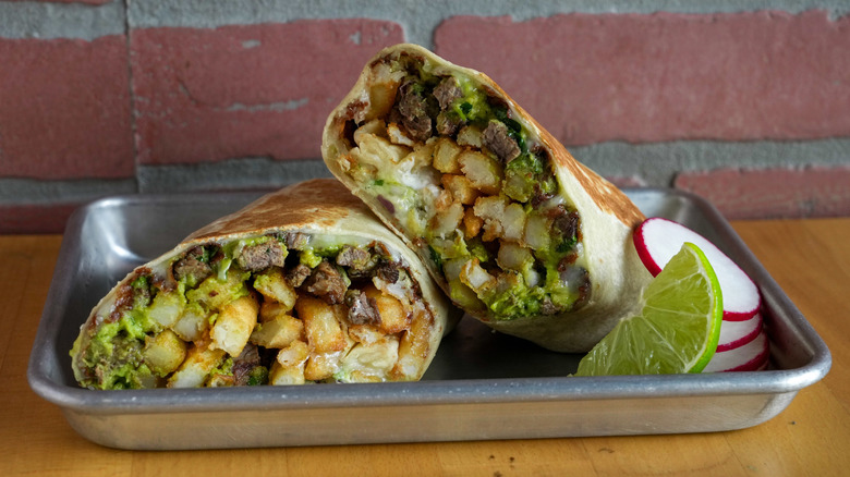 A California burrito cut in half on a plate