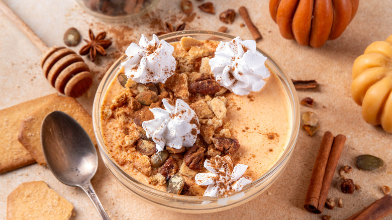 Yogurt bowl with pumpkin puree and seeds, pecan nits, graham crackers, topped with whipped cream and cinnamon