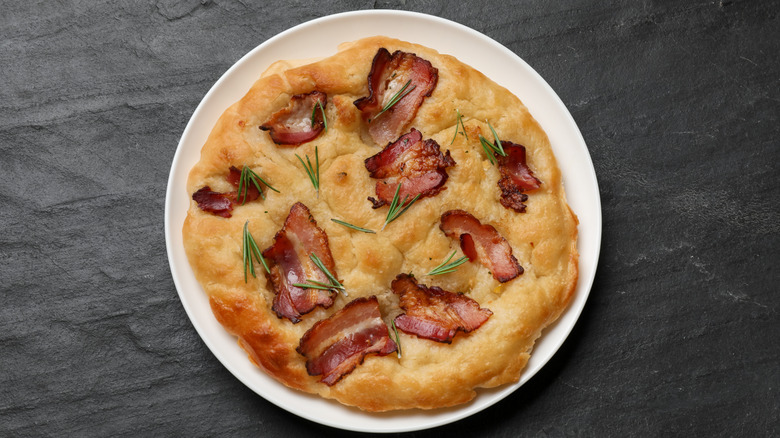 Focaccia made with bacon on a round white plate