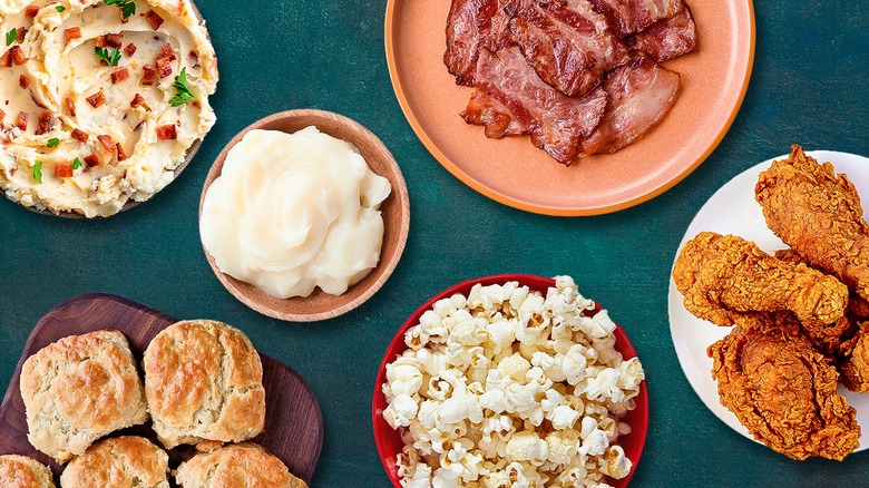 Assorted foods that contain bacon grease including mashed potatoes, popcorn, biscuits, and fried chicken