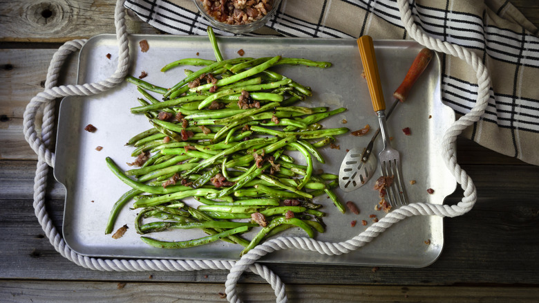 Bacon roasted green beans on a baking sheet