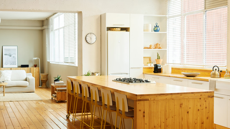 Butcher block countertops in a sunlit kitchen with a wooden floor
