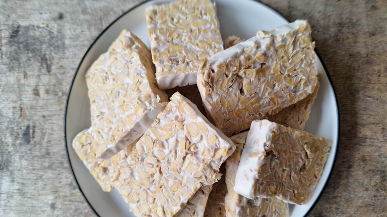 Dry tempeh blocks piled on plate