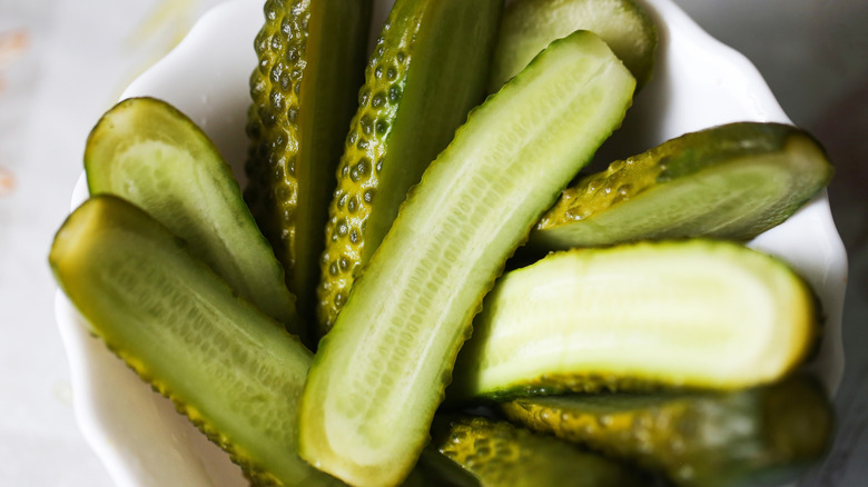 Overhead closeup view of a bowl of sliced pickles