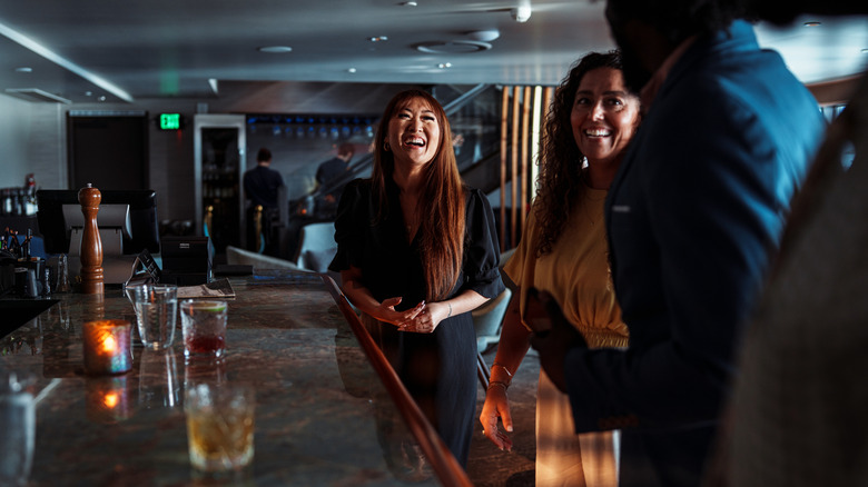People socializing at a dark bar