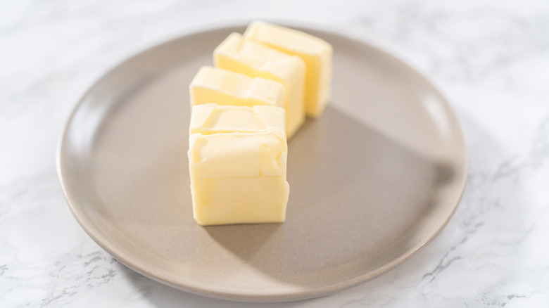 Softened pieces of butter on a beige plate