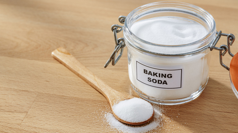 Spoon and glass jar of baking soda