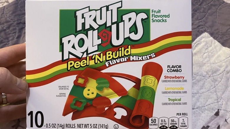 A hand holding a box of Fruit Roll-Ups Peel 'n Build