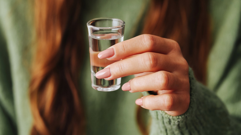 Woman holding vodka shot