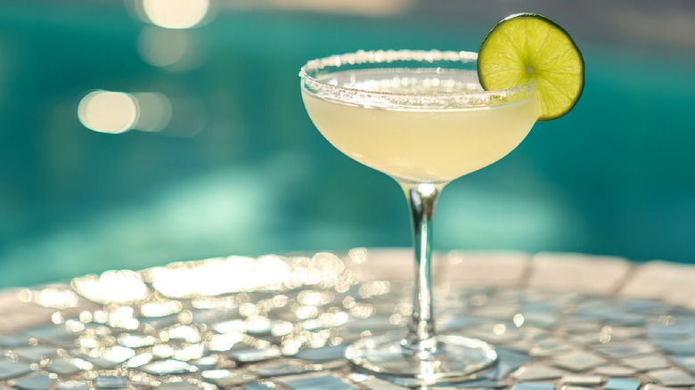 Salt-rimmed cocktail by pool
