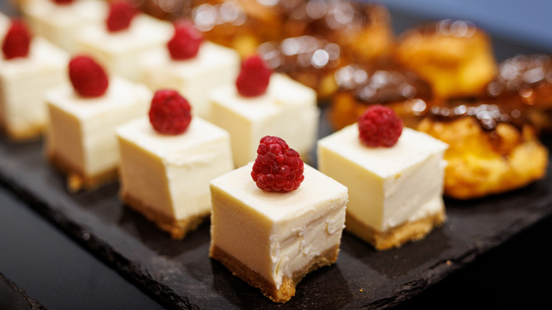 Mini cheesecake squares on black serving tray