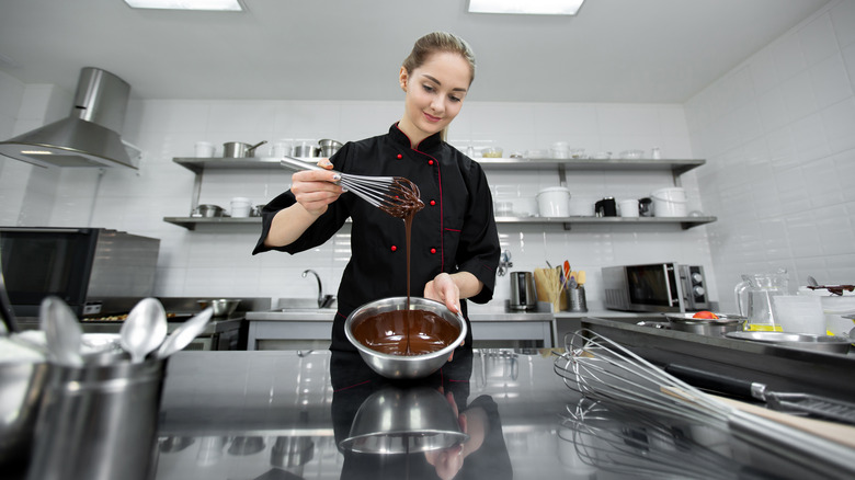 Pastry chef stirring ganache in bowl
