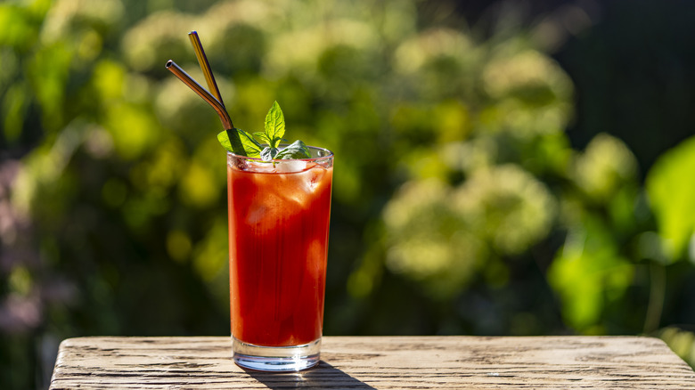 Bloody Marys on wooden table in front of garden view