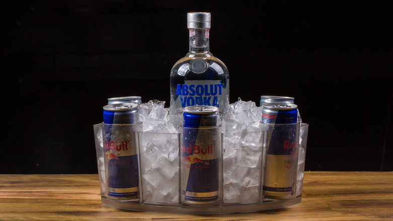 Red Bull and vodka in ice cooler on wooden table