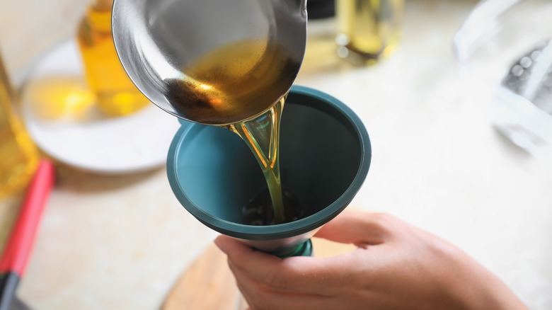 Pouring oil into funnel