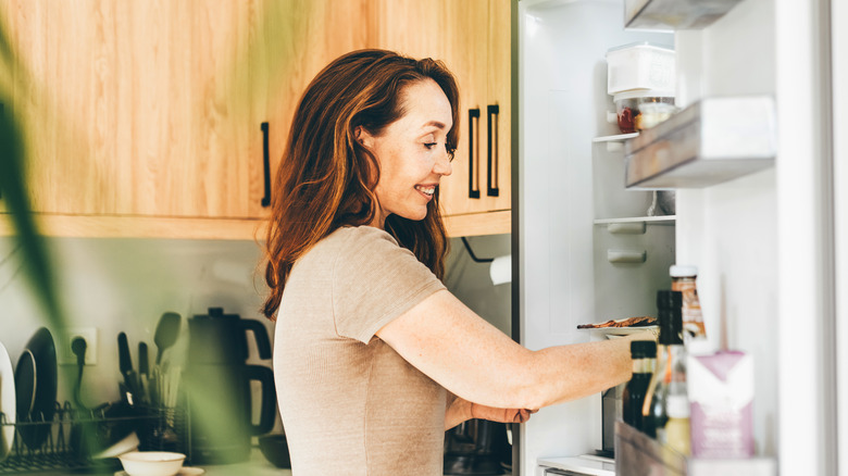 Woman is taking food from the refrigerator