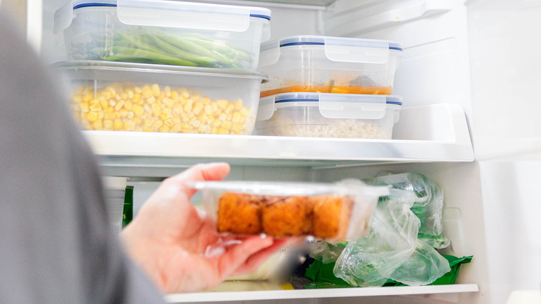 Person pulling container from refrigerator