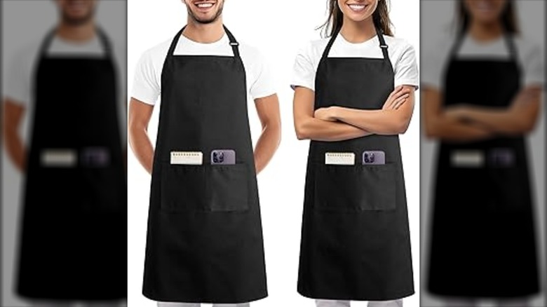 A man and woman wearing black aprons