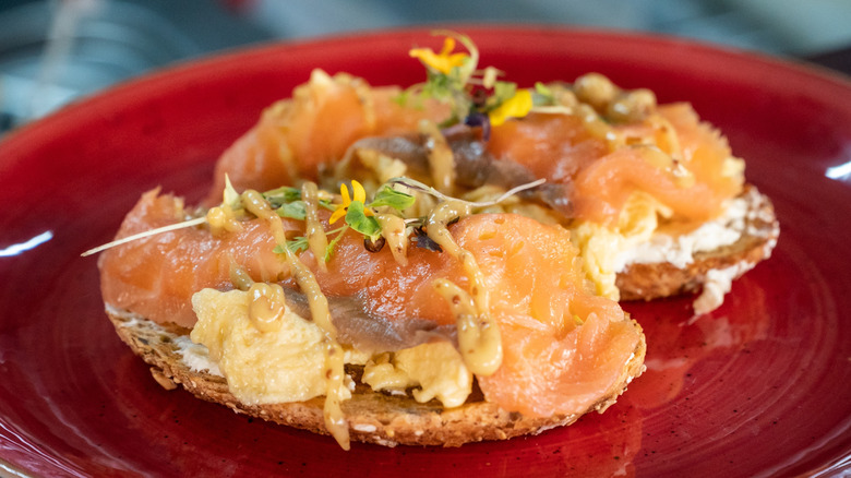 smoked salmon with scrambled eggs served open-faced on bread