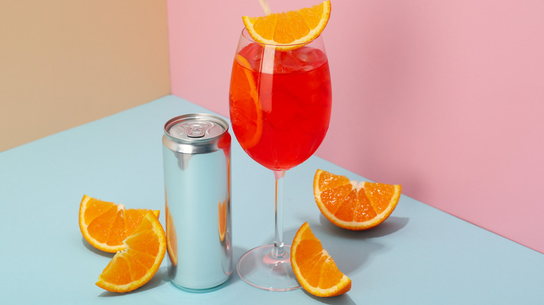 A canned spritz cocktail sits on a kitchen counter with orange slices