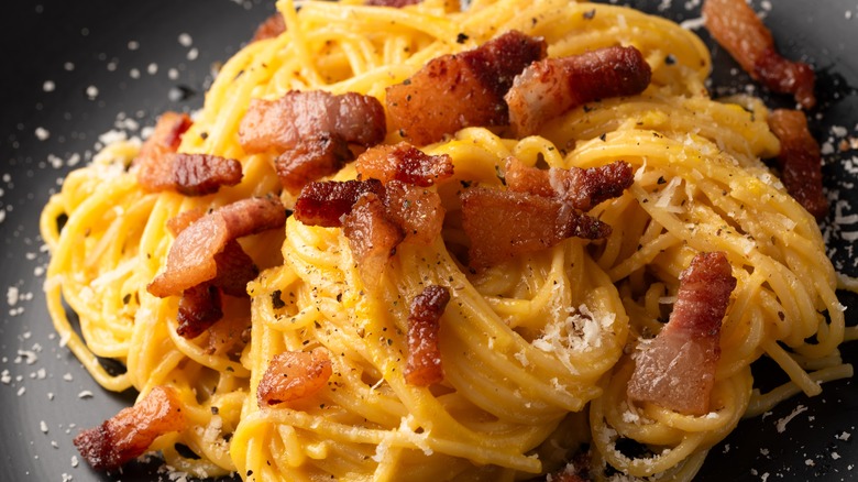 Spaghetti with carbonara sauce including pancetta, pecorino, and parmesan cheese