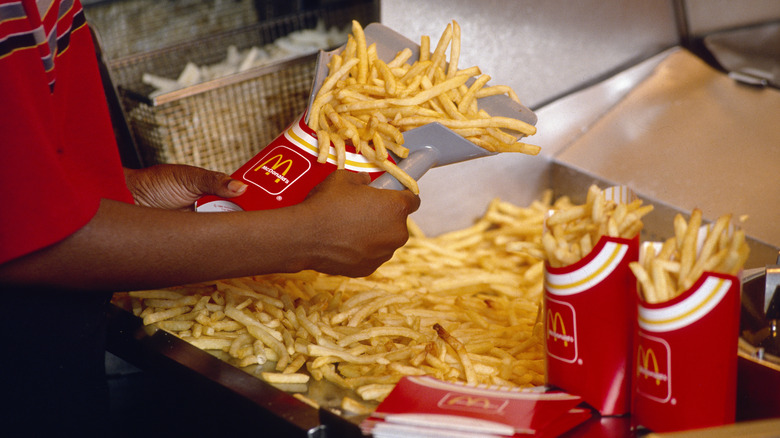worker scoops McDonald's fries into carton