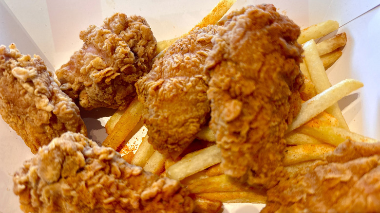 Close up of KFC chicken with fries underneath