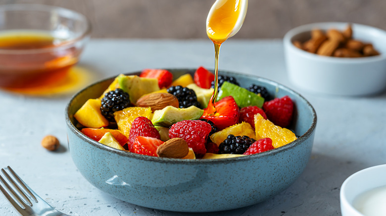Bowl of fruit salad topped with honey sauce