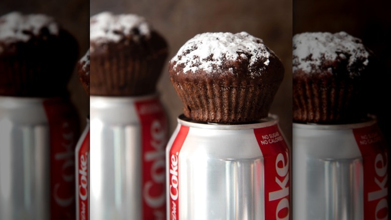 Coca Cola cupcakes sitting atop cans of Coca Cola