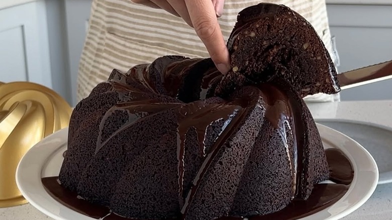 A slice being removed from a Tunnel of Fudge Cake